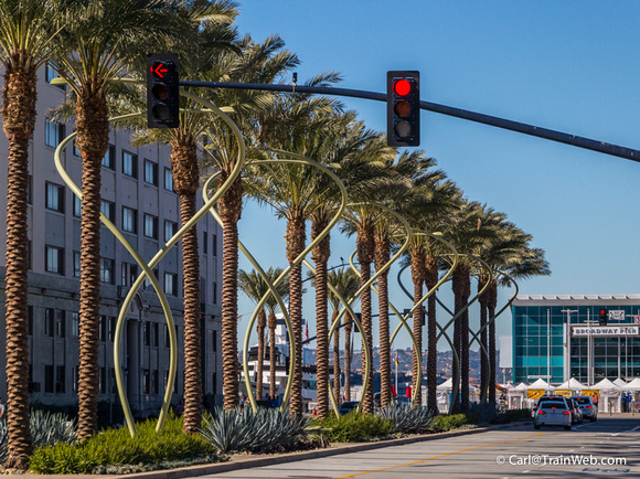 New palm trees and light poles between the station and the wharf.