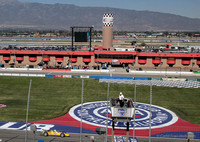 Finish line, flag stand, pits, suites, and mountains beyond Fontana, California